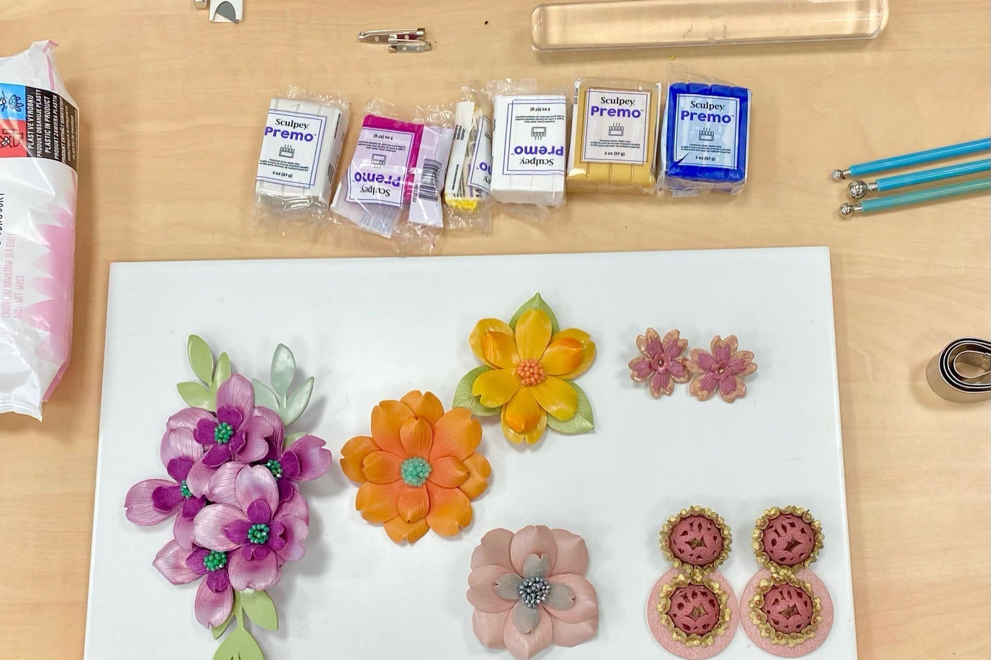 Bloques de arcilla polimérica Sculpey Premo y ejemplos de flores y aretes hechos con la arcilla