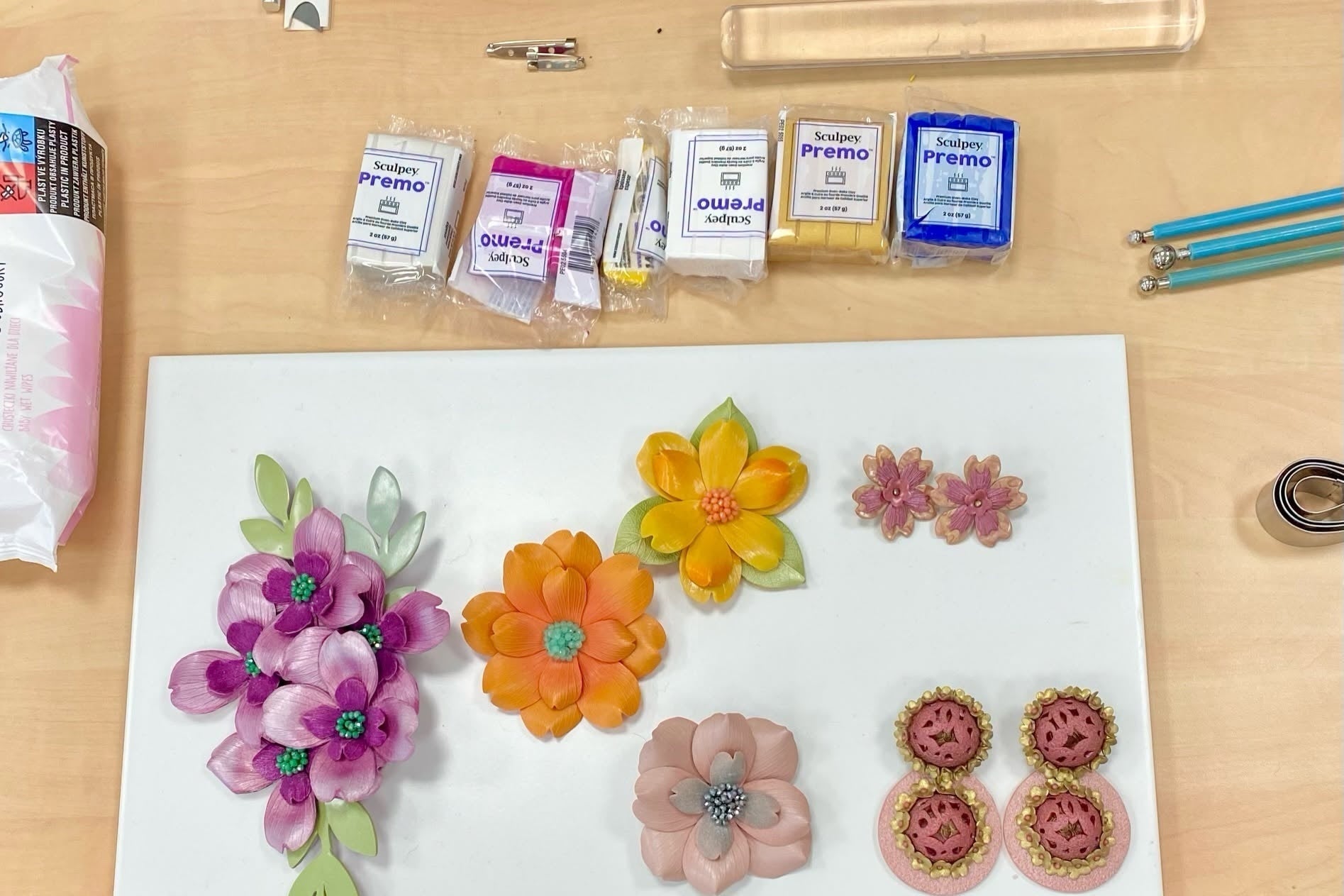 Bloques de arcilla polimérica Sculpey Premo y ejemplos de flores y aretes hechos con la arcilla